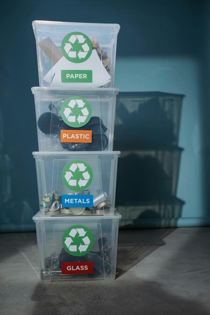 pexels-photo-6591429-6591429 Vertical shot of labeled recycling bins for paper, plastic, metals, and glass.